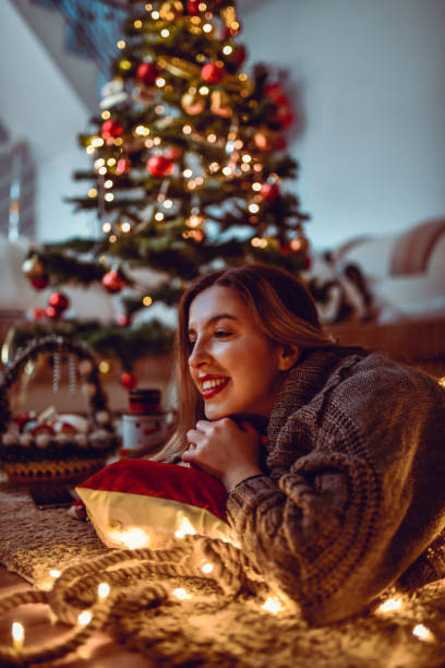 istock Female Relaxing On Floor Pillow Under Christmas Tree 1285174288