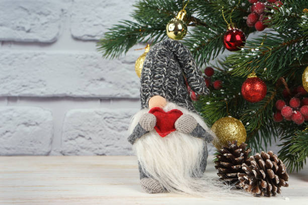 A handmade male gnome featuring a tall purple hat, white beard, and gray body with matching purple accents on the gloves and shoes. This decorative piece adds a touch of charm and elegance to any seasonal or festive setup.