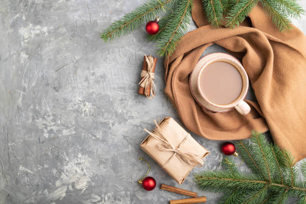 istock Christmas or New Year composition. Decorations, box, cinnamon, fir and spruce branches, cup of coffee, wool scarf on a gray concrete background. Top view, copy space, flat lay. 1285177011