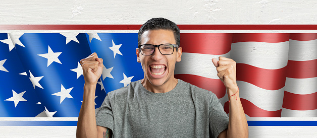 Latin american man celebrating in front of american flag