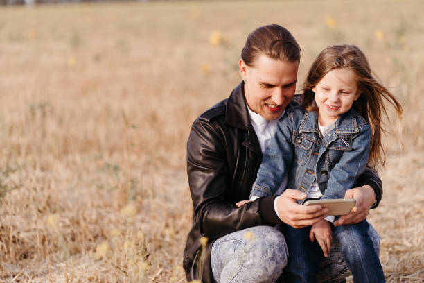 istock Father and daughter playing games with cell phone 1285178429