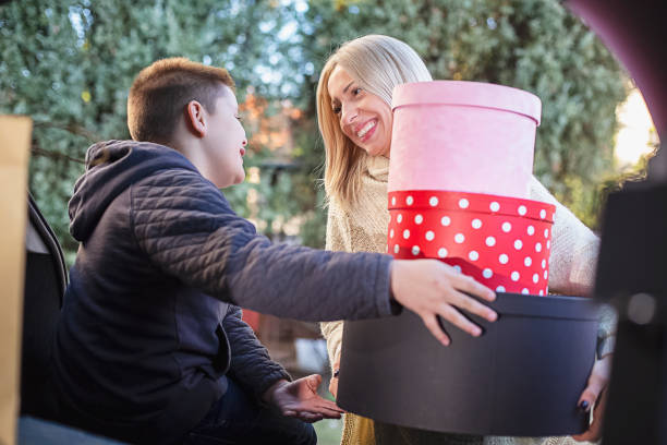 istock Mother with her son packing Christmas presents in a car trunk 1285178440