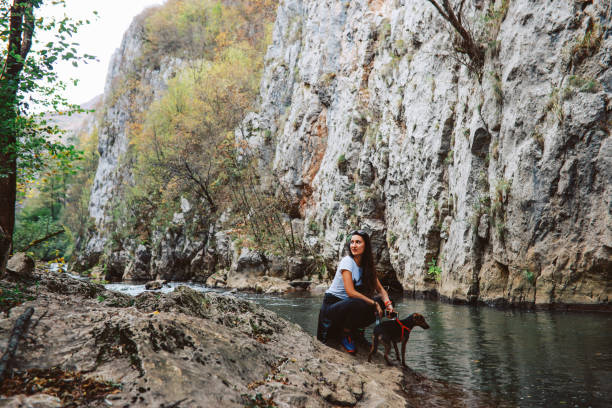 istock Woman with a dog by the forest stream 1285180263