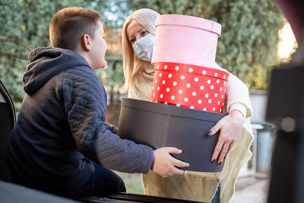 istock Mother with her son packing Christmas presents in a car trunk 1285180904