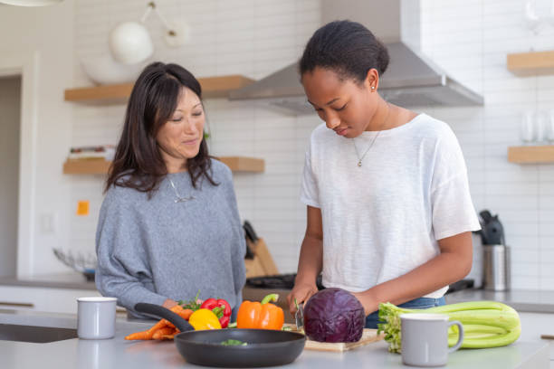istock Teenage daughter cooking dinner with her mom 1285181717
