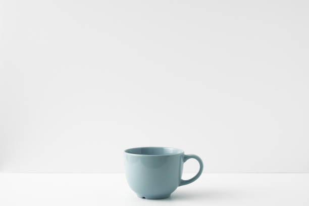 la tasse se tient sur une table blanche sur un fond blanc. copier l’espace, se moquer - 13412 photos et images de collection