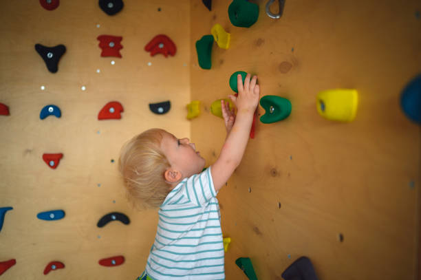istock Caucasian Boy Climbing on a Gym Climbing Wall at Home 1285182569