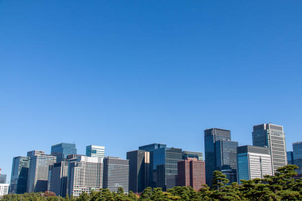 современные офисные здания на фоне голубого неба - marunouchi clear sky urban scene low angle view стоковые фото и изображения