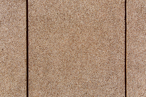 wall texture with a granular coating of moisture resistant tar, a close-up of a building facade with copy space, nobody.