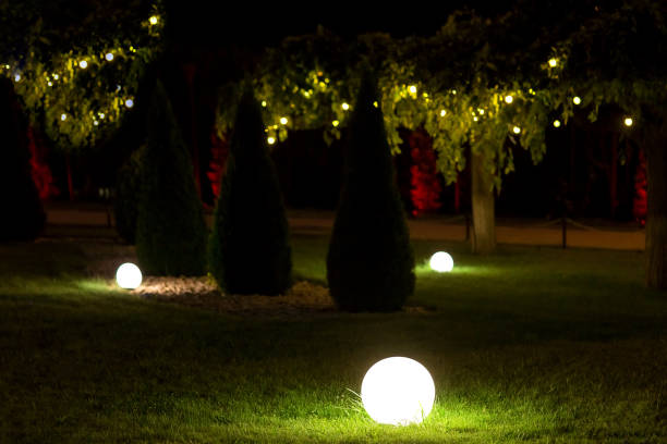 istock illumination landscape light backyard with electric ground lantern with round diffuser lamp with garland of light bulbs on background, dark park landscaping with illuminate night scene. 1285184978
