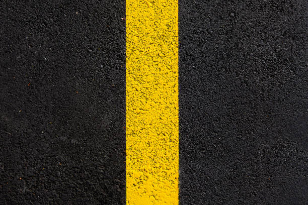 istock texture tarmac highway road surface with yellow marking smooth dark gray asphalt with copy space close up top view, nobody. 1285184995