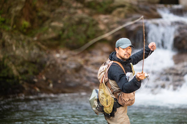 istock Man Fly Fishing in a mountain river with a waterfall 1285185746