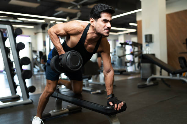 istock Fit man flexing his biceps in a gym bench 1285187281