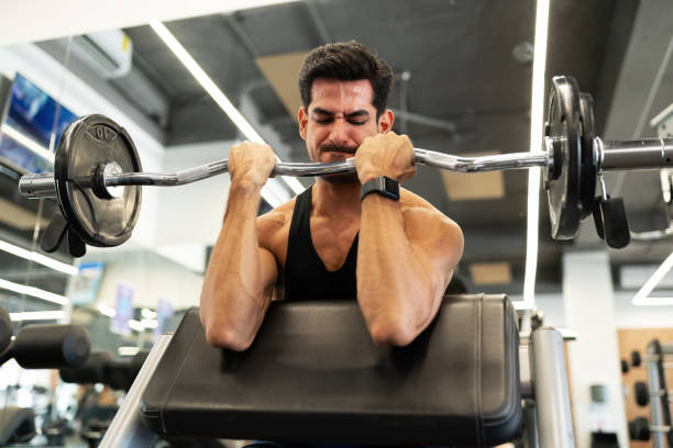 istock Latin man training hard with gym weights 1285187378