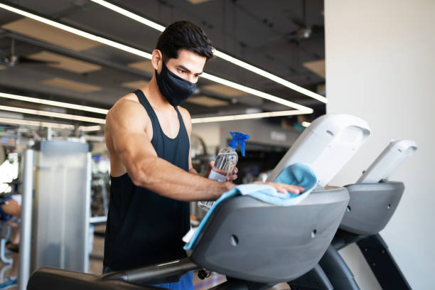 istock Hispanic man desinfecting the gym equipment 1285187419