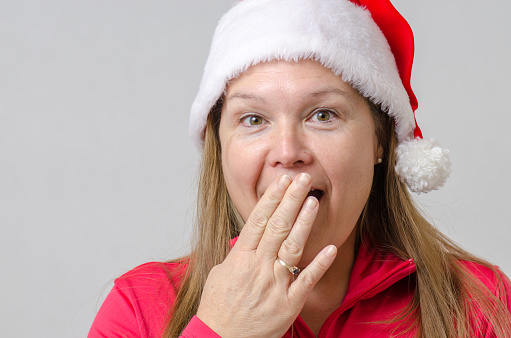 Headshot of surprised woman with Christmas hat