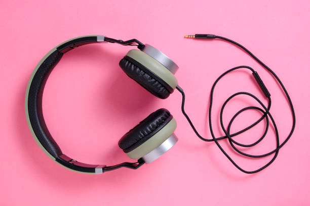 istock Wired headphones in khaki on a pink background. 1285188427