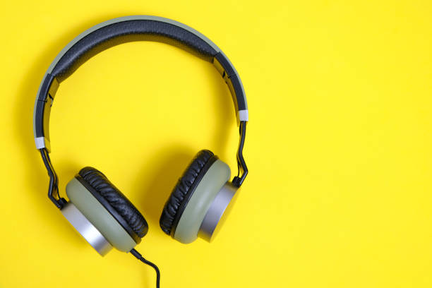 istock Wired headphones in khaki on a yellow background. 1285188433