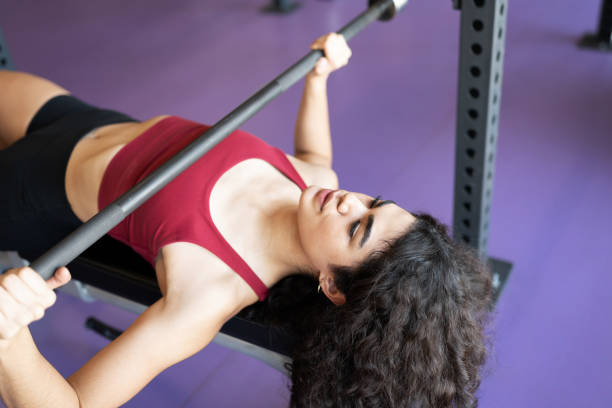 istock Young hispanic woman lifting weights at the gym 1285189717