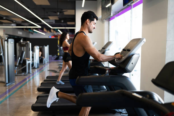 istock Fit latin man using a treadmill at the gym 1285189833