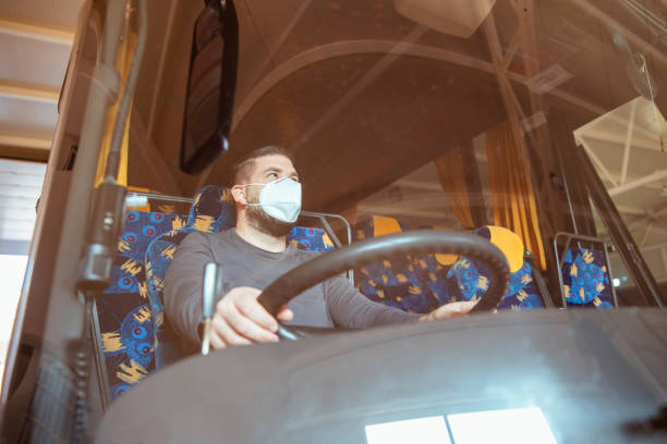 istock Professional bus driver in white protective suit wearing mask 1285192510