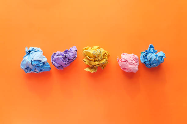 istock top view of crumpled paper balls on orange background 1285192537