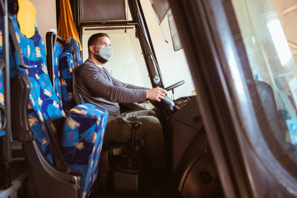 istock Professional bus driver in white protective suit wearing mask 1285192624