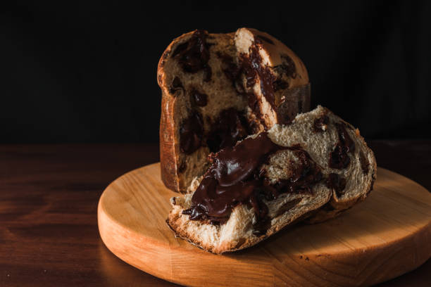 Chocolate panettone slice on dark background. Chocolate panettone slice on dark background. Panettone of chocolate known in Brazil as chocottone. fusion food photos stock pictures, royalty-free photos & images