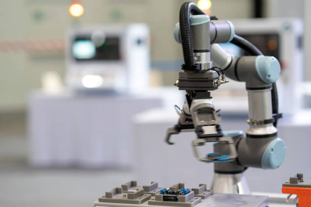 istock Factory 4.0 concept : View of Gripper on universal robot is moving  with transfer IC board on automatic conveyor in smart laboratory. 1285196543