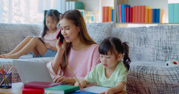 istock Asian Young mother working at home with two daughters 1285200253