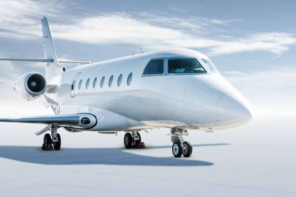 istock Modern white business jet isolated on light background with sky 1285208454