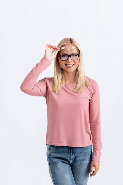 istock Smiling blonde woman holding eyeglasses while looking at camera isolated on white 1285209181