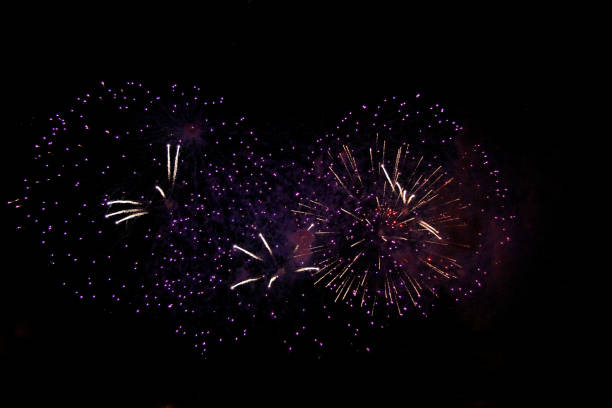 istock The Celebration colored firework flashing in the black night sky background in violet colors 1285210210