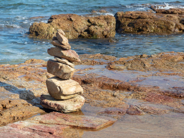 istock Balanced zen stones on the beach with blue sky and sea background. 1285213766