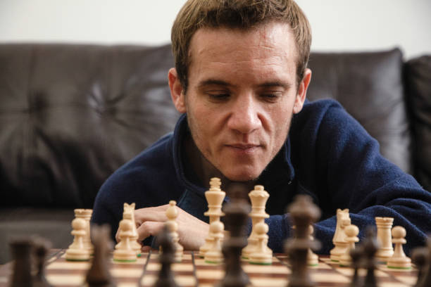 Close-up on pensive trans autistic male over a chess board