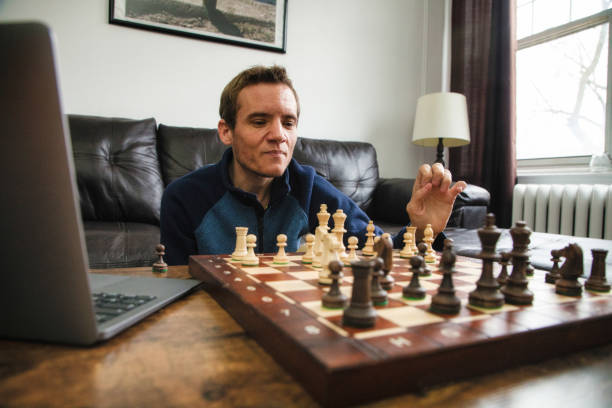 istock Quarantined autistic man learning chess through video conference on laptop 1285213906