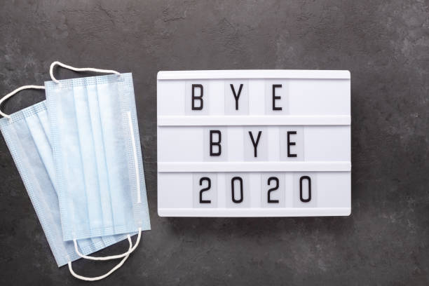istock Lightbox with text BYE BYE 2020 with medical mask on dark background. Top view. New year celebration. Happy New Year 2021 concepts 1285215956