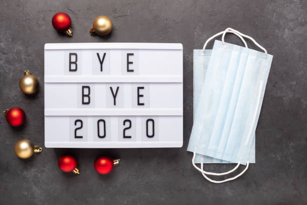 Lightbox with text BYE BYE 2020 with medical mask on dark background. Top view. New year celebration. Happy New Year 2021 concepts