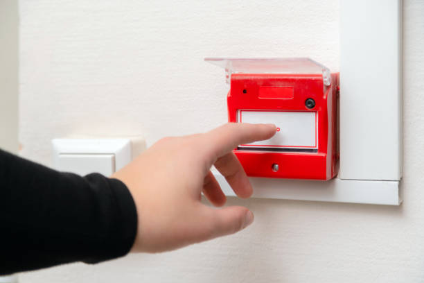 handdrücken des feueralarmknopfes in der schule oder im geschäftsbüro. nahaufnahme der schutzkonsole gegen flammenschäden - glass sign office security stock-fotos und bilder