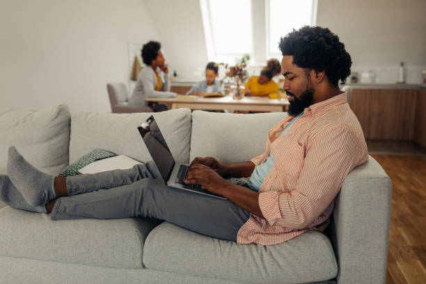 istock Black man with earphones sitting on the floor and using laptop 1285221318
