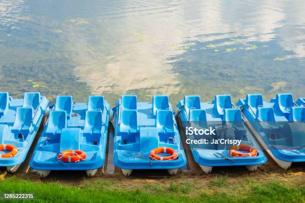 Plastic Rental Pedal Boats Parked On The Lake Shore On A Sunny Day Active Rest Outdoors Nobody Stock Photo - Download Image Now