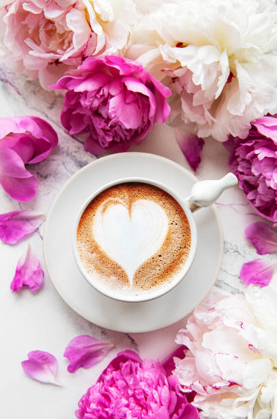 istock Pink peony flowers and cup of coffee 1285223419
