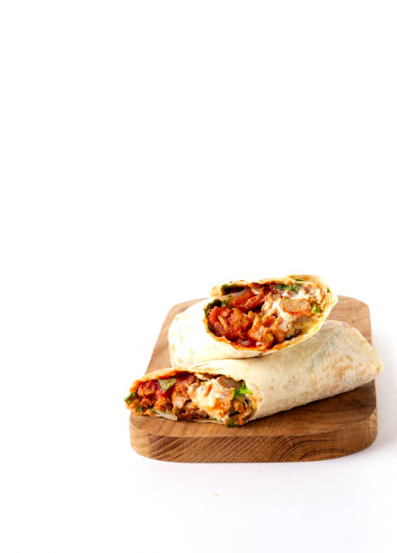 istock shawarma, roll in lavash , grilled meat, with vegetables, sandwich , cut on a white background, vertical, copy spase 1285224662