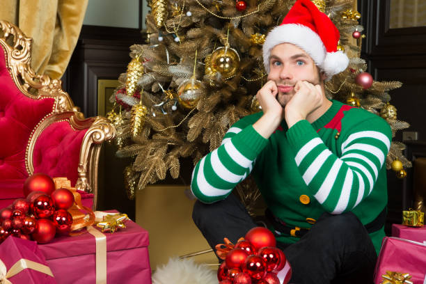 istock Macho with serious face in santa hat prepare gift boxes 1285226275