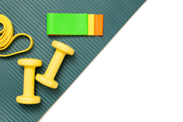 istock Flat view sports set: dumbbells and a set of multi-colored elastic bands 1285227724