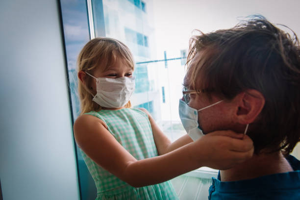istock daughter put mask on dad before going outside 1285228819