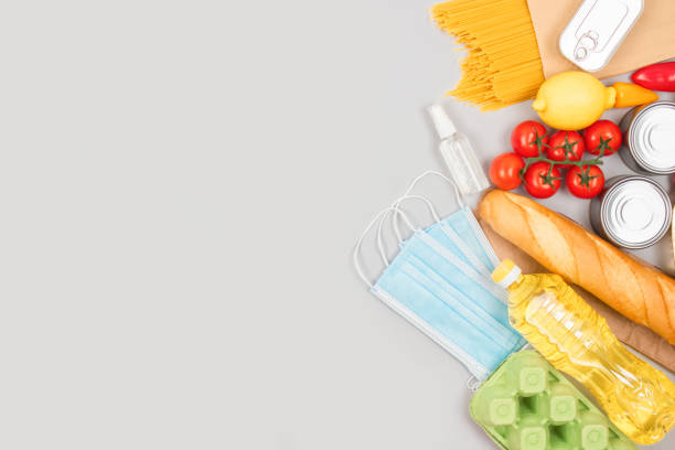 istock Flat lay composition with food and medicines donations on grey background with copyspace - pasta, fresh vegatables, canned food, baguette, cooking oil. Food donations and food bank concept 1285231603