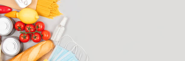 istock Banner with food and medicines donations on grey background with copyspace - pasta, fresh vegatables, canned food, baguette, cooking oil. Food donations and food bank concept, flat lay 1285231606