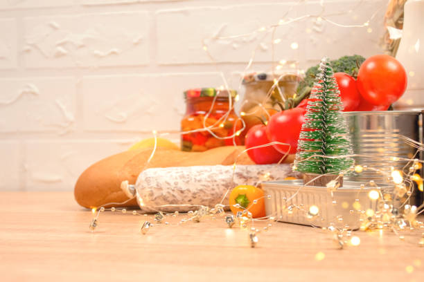 istock Christmas donations - food donations on light background with copyspace - pasta, fresh vegatables, canned food, baguette, cooking oil with Christmas decorations. Food bank. Selective focus 1285231611