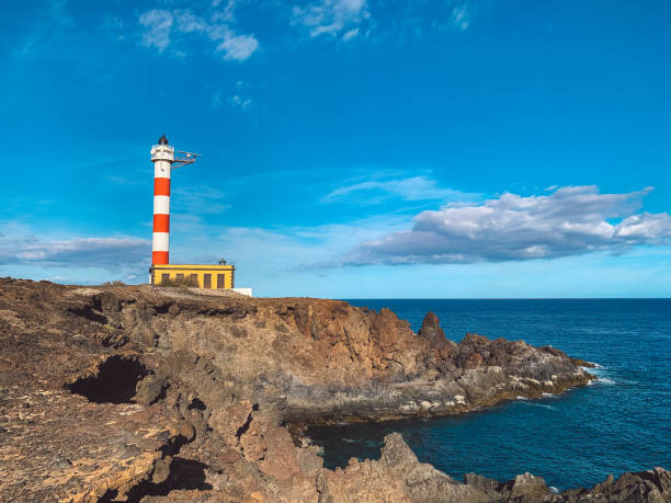 istock Lighthouse On Rock By Sea Against Blue Sky 1285231704